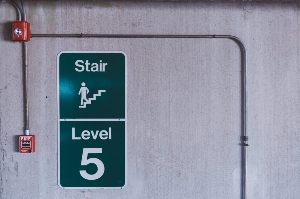 pexels-photo-103592 A fire alarm and stair sign on level 5 in an industrial indoor setting.