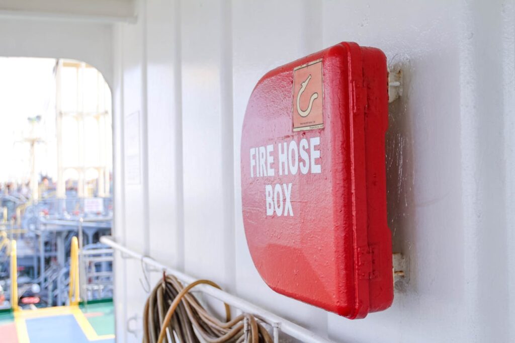 pexels-photo-241025 Close-up of a bright red fire hose box on a ship deck, emphasizing safety.